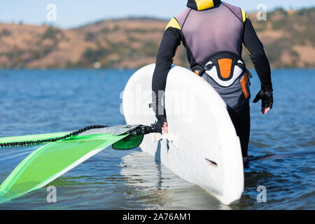 Nahaufnahme von Windsurfer Surfboard mit Segel im flachen Wasser. Stockfoto