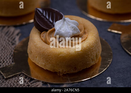 Kuchen Tanks mit Pumpkin spice Creme gefüllt, mit Schokolade Blätter und kleine Royal icing Kürbissen dekoriert Stockfoto