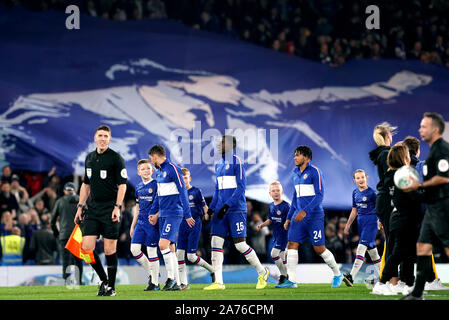 Chelsea Spieler gehen Sie auf die Tonhöhe als Fans auf den Tribünen halten ein Banner von Chelsea Frank Lampard vor Beginn der Carabao Schale, vierten Runde an der Stamford Bridge, London. Stockfoto