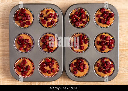 Zwei Backbleche mit rohen Kuchenteig und Kirschen Stockfoto