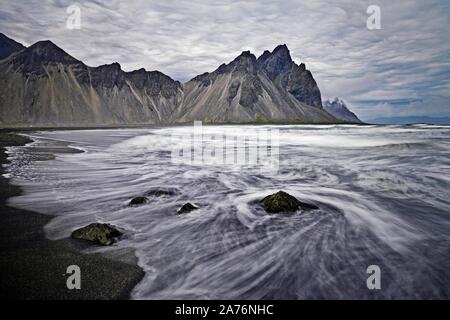 Berg Vestrahorn, schwarze Lava Strand mit Surf am Kap Stokksnes, Hornvik Bay, Südosten Island, Island Stockfoto