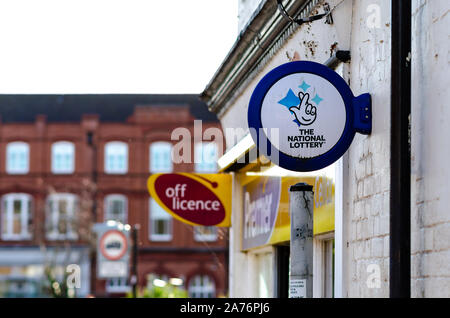 Die nationalen Lotterie- und Off-Licence-Werbeflächen, die auf dem Ladengebäude in Stone, Staffordshire, Großbritannien zu sehen sind. Stockfoto