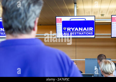 Passagiere warten an Ryanair Abfertigungsschalter am Flughafen von Charleroi. Stockfoto