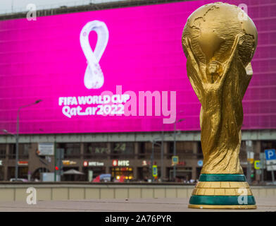 4. September 2019, Moskau, Russland. Kopie der wm-pokal auf Hintergrund Logo der FIFA WM 2022, die in Katar stattfinden wird, auf einem riesigen scre Stockfoto