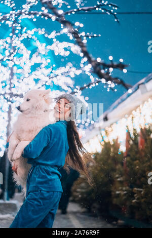 Eine Frau trägt Ihr Hund in ihre Arme. Stockfoto