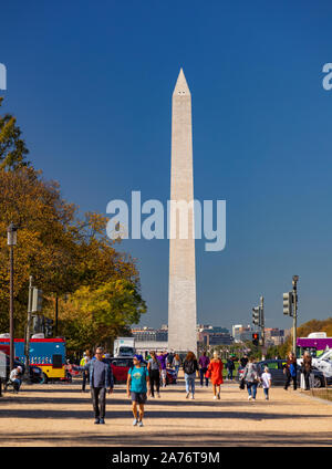 WASHINGTON, DC, USA - Menschen laufen auf der National Mall, vor dem Washington Monument. Stockfoto