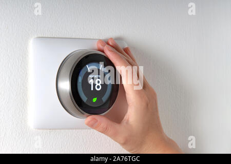 Smart Thermostat mit einer Hand Energie sparen Stockfoto