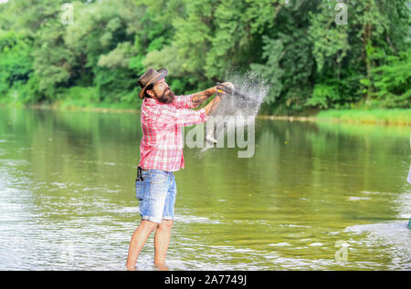 Trout Farm. Fischer allein im Wasser des Flusses. Mann bärtigen Fischer. Fischer Angelausrüstung. Hobby Sport. Ruhige und friedliche Stimmung. Eine Art der Meditation. Fische in der Regel in freier Wildbahn gefangen. Stockfoto