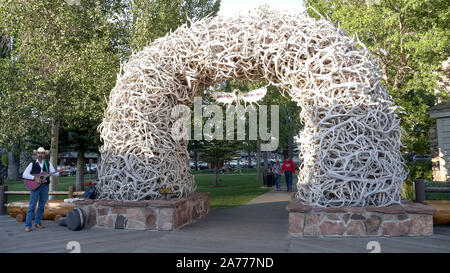 JACKSON HOLE, Wyoming, USA - 17. AUGUST 2017: einen weiten Blick über ein strassenmusikant stand neben einem geweih Arch in Jackson Hole Stockfoto