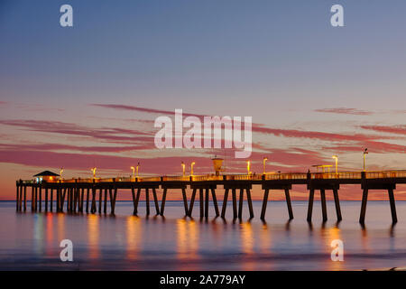 Fishing Pier bei Sonnenuntergang auf Okaloosa Island, Florida, USA, mit Promenade Lichter auf dem Zeigen Reflexionen im Florida Panhandle Golf von Mexiko. Stockfoto