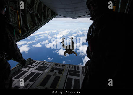 Us-Marines mit 3 Reconnaissance Bataillon, 3rd Marine Division verhalten Fallschirm Operationen durch einen Sprung aus einem KC-130 Hercules auf Ie Shima, Okinawa, Japan, Oktober 28-30, 2019. Diese kombinierte Ausbildung inklusive Marines vom 3. Transport Support Battalion, 3. Marine Logistik Gruppe, sowie Unterstützung von Marine Antenne Refueler Transport Squadron 152 und Marine Light Attack Helicopter Squadron 169, 1 Marine Flugzeugflügel. Diese militärische Ausbildung stellt sicher, dass die Marines von III Marine Expeditionary Force werden ständig geschult und Lieferungen von Personal oder Equipme zur Verfügung zu stellen Stockfoto