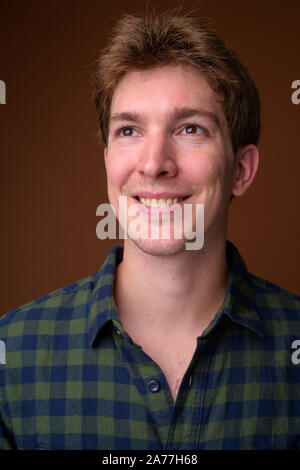 Gesicht der jungen Hübschen hippie Mann in Grün kariertem Hemd Stockfoto