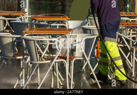 Nasse Reinigung Boden von Street Cafe mit unter Druck stehendem Wasser. Stockfoto