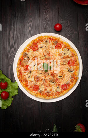 Sortierte Pizza in Stücke auf einem dunklen Hintergrund, in Scheiben geschnitten Stockfoto