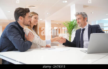 Paar Hände schütteln mit real estate agent nach dem Kauf Haus Stockfoto