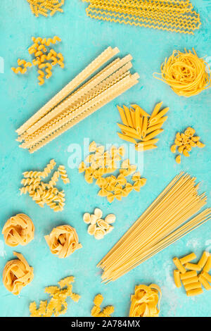 Italienische Pasta Flach, Plakat, geschossen von oben auf blauem Hintergrund. Spaghetti, Penne, farfalle und andere Arten, Ansicht von oben Stockfoto