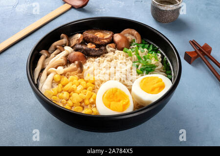 Ramen. Soba Nudeln mit Eiern, Champignons, und Gemüse, mit Willen, traditionellen hölzernen Löffel und Essstäbchen Stockfoto