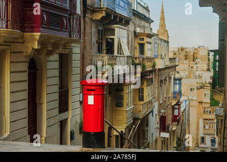 Rot traditionelle Postbox in Valletta, Malta. Mit alten Balkonen auf Hintergrund Stockfoto