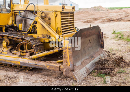 Nahaufnahme der Raupe Planierraupe Truck. Erdbau schwere Maschinen. Gelbe crawler Maschinen. Gelbe Schlepper auf Caterpillar Tracks, Traktor Titel Stockfoto