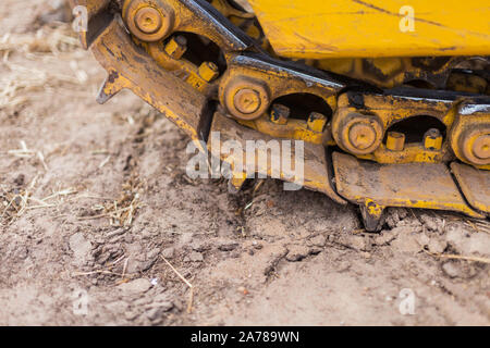 Nahaufnahme der Raupe Planierraupe Truck. Erdbau schwere Maschinen. Gelbe crawler Maschinen. Gelbe Schlepper auf Caterpillar Tracks, Traktor Titel Stockfoto