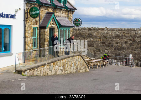 23. August 2019 Kunden mit einem Rauch von außen eine kleine Kneipe im Hafen Dorf Mullaghmore County Sligo Irland Stockfoto