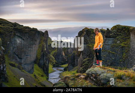 Junge Wanderer stehen am Rande des Fjadrargljufur Canyon in Island Stockfoto