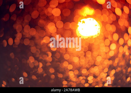 Die Orange Night Light bokeh Hintergrund. Das Leben in der Stadt. Blur abstrakt Hintergrund der städtischen Licht. Warmes Licht mit schönen Muster der Runde. Weihnachten Stockfoto