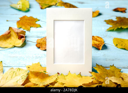 Herbst Zusammensetzung Hintergrund. Gelb und Rusty verlässt t auf Blau Holz- Hintergrund mit leeren Bilderrahmen für Text. Top Anzeigen, Kopieren, flach. Stockfoto