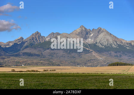 Die Lomnitzer Spitze in der Hohen Tatra aus einem Feld gesehen Stockfoto