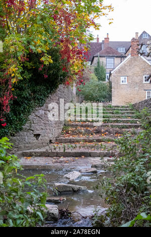 Alte Trittsteine über den Fluss Brue in der Nähe von packesel Brücke im Bruton, Somerset UK, fotografiert im Herbst mit Farben des Herbstes. Stockfoto