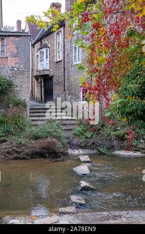 Alte Trittsteine über den Fluss Brue in der Nähe von packesel Brücke im Bruton, Somerset UK, fotografiert im Herbst mit Farben des Herbstes. Stockfoto