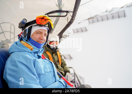 Bild von zwei Snowboarder in Helm und Maske am Kabel Auto auf Winter Tag Stockfoto