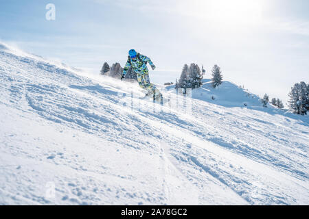 Foto der Sportler in Helm Snowboarden im Winter Resort am Nachmittag Stockfoto