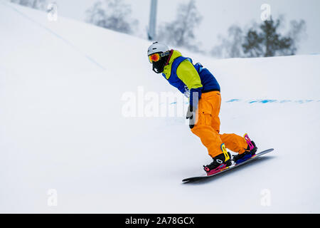 Männliche snowboarder Absteigend einen verschneiten Hang Stockfoto