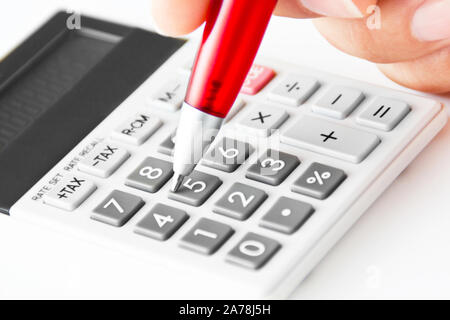 Taschenrechner und Hand mit roter Stift Stockfoto