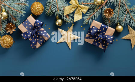 Weiten Bogen Weihnachten Grenze auf blauem Hintergrund, bestehend aus Xmas Tree Tannenzweigen und Ornamente in golden und blau geprägt. Flach, Ansicht von oben, overhea Stockfoto