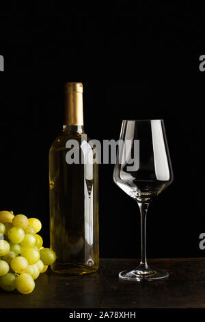 Eine Flasche Wein, ein Glas und eine Weintraube Stockfoto
