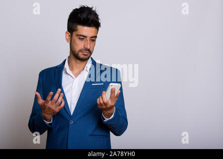 Die Jungen gut aussehenden bärtigen Persischen Geschäftsmann in Phone Anzug Stockfoto