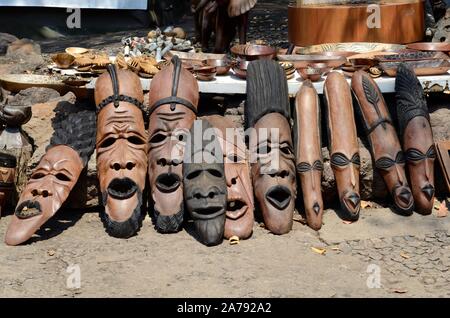 Aus geschnitztem Holz Holz- zeremoniellen tribal Masken zum Verkauf an einer Straße Markt Simbabwe Afrika Stockfoto