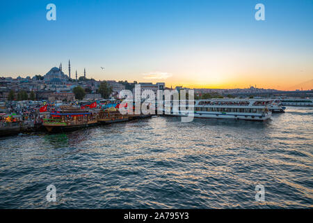 Blick auf das Goldene Horn und die Suleymaniye Moschee bei Sonnenuntergang mit touristischen Boote im Vordergrund. Stockfoto