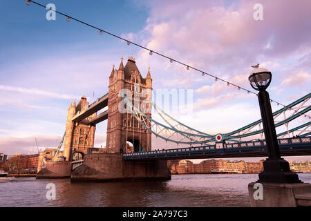 Die Tower Bridge, eine der berühmten Londoner Brücken und einer von vielen muss - siehe Sehenswürdigkeiten in London im warmen Abendlicht. Breite Seite anzeigen Stockfoto