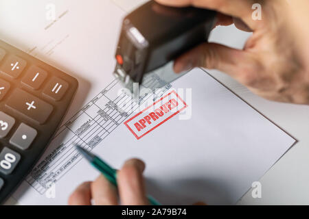 Ausschreibung Abnahme - Hand einen genehmigt Stempel auf der Rechnung Stockfoto