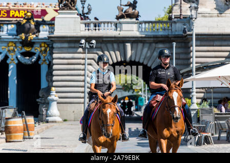 Zwei Polizisten auf Pferden patrouillieren durch den Gang des Flusses seine in der Innenstadt von Paris, Frankreich. Stockfoto