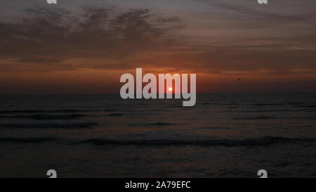 Sonnenaufgang über dem Meer. Die Sonne zeigt und Färbung der Himmel in Rot und Goldgelb. Stockfoto