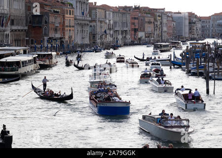 Gedeckte Farben eines langen Szene auf dem Canal Grande, Venedig. Mit Wassertaxis, Wasser Busse gepfercht, Gondeln gegen die bunten Gebäude Stockfoto