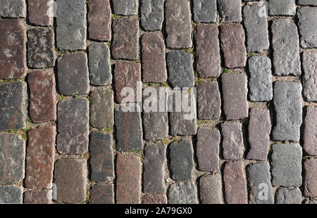 Altes, dunkles Pflastersteine Kopfsteinpflaster draußen als Hintergrund der Ansicht von oben schließen Stockfoto