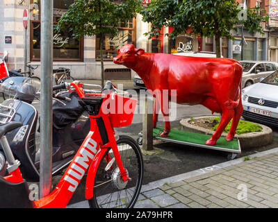 Life-size Red Cow Skulptur an der Ecke der Straße in Saint Gilles, Brussel, Belgien. Stockfoto