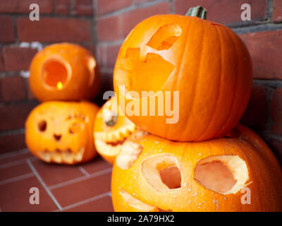 Fünf Kürbisse geschnitzt für Halloween auf einer Tür in England bereit für Trick oder Festlichkeit Türklopfer Stockfoto