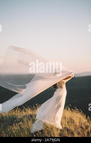 Schöne Braut Frau in weißem Kleid auf dem Feld. Bildende Kunst, Hochzeit, Glück, Leben, Liebe, Leben Konzept Stockfoto