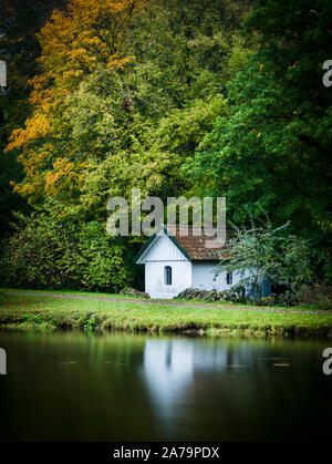 Ein kleines Haus in einem See mit Reflexion. Stockfoto